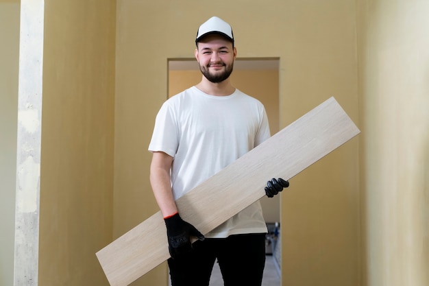 Foto gratuita hombre sonriente que sostiene el tiro medio del azulejo