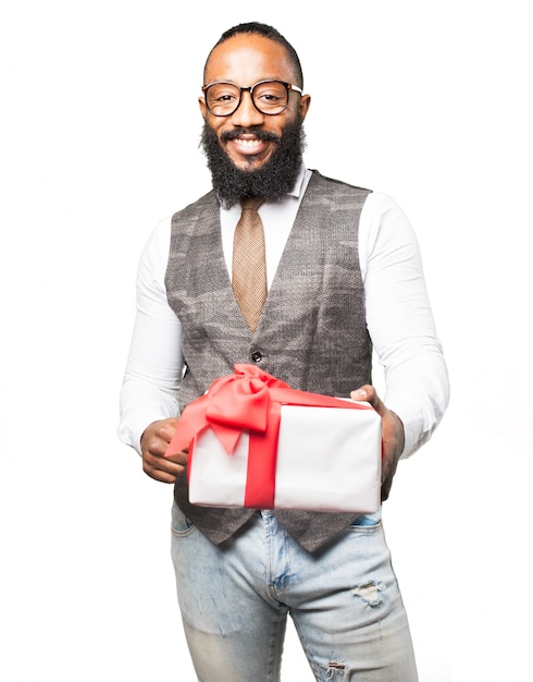 Hombre sonriente con un regalo blanco con lazo rojo