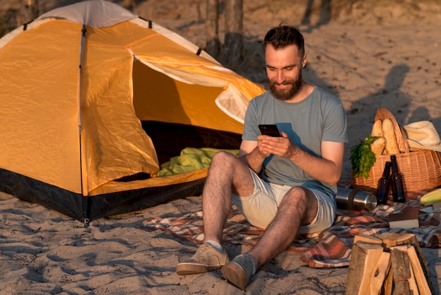 Foto gratuita hombre sonriente revisando su teléfono inteligente