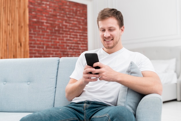 Hombre sonriente revisando sus notificaciones