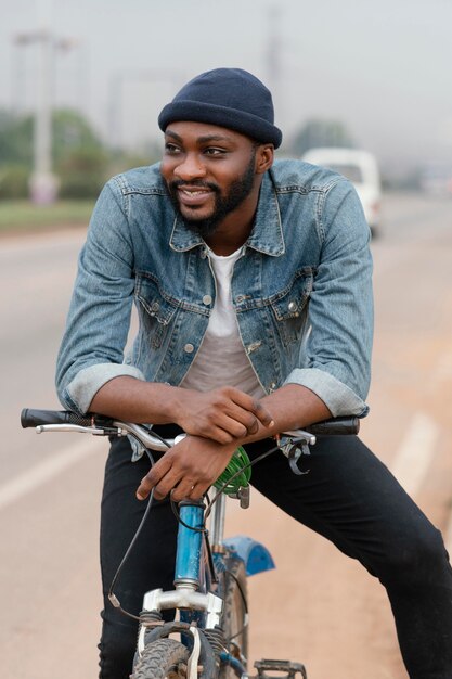 Hombre sonriente sonriente posando con bicicleta
