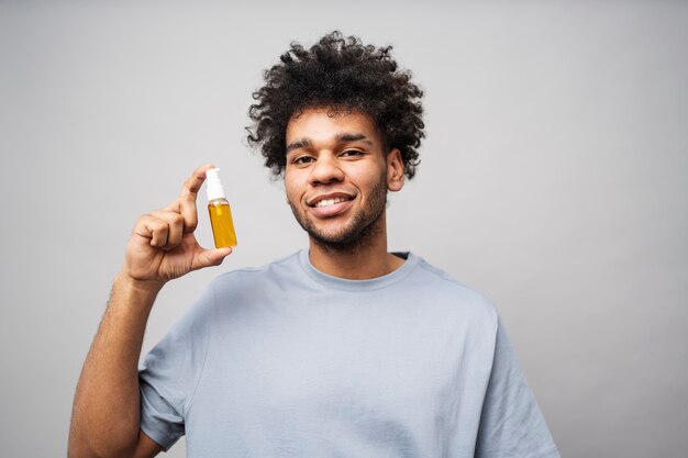 Hombre sonriente sosteniendo botella de suero tiro medio