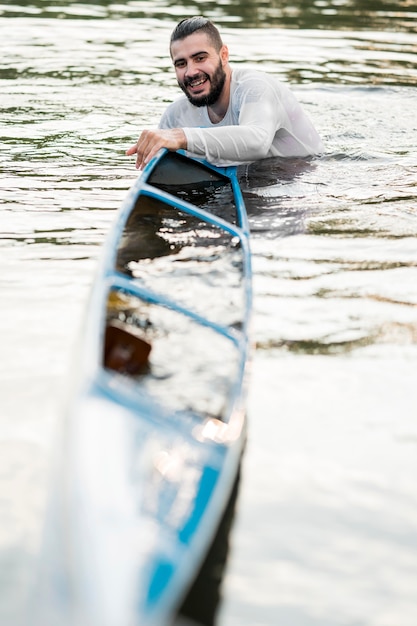 Foto gratuita hombre sonriente sosteniendo su kayak