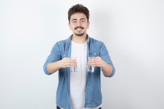 hombre sonriente sosteniendo un vaso de agua en blanco.
