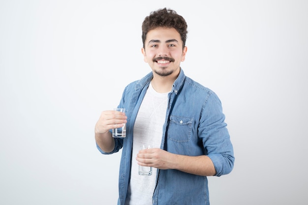 hombre sonriente sosteniendo un vaso de agua en blanco.