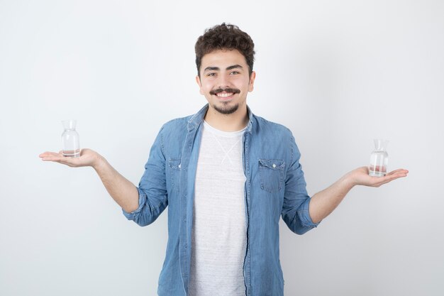 hombre sonriente sosteniendo un vaso de agua en blanco.