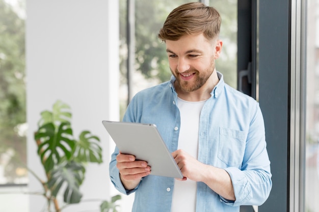 Foto gratuita hombre sonriente con tableta