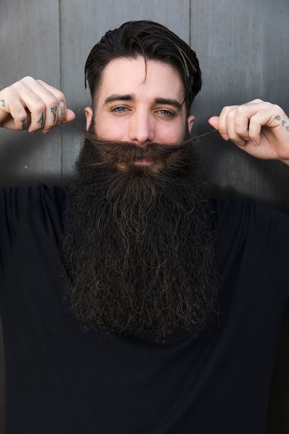 Foto gratuita hombre sonriente tirando de su bigote