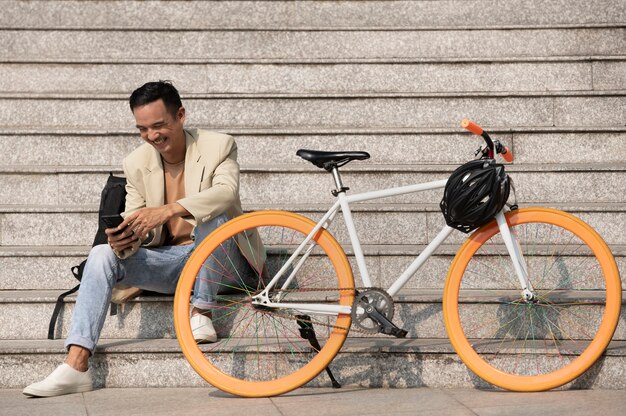 Hombre sonriente de tiro completo con bicicleta