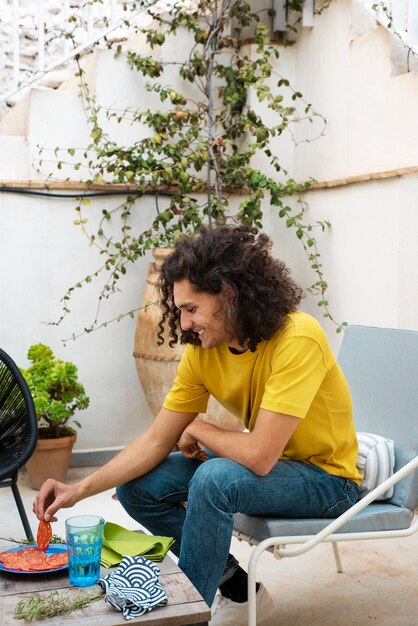 Hombre sonriente de tiro completo con comida