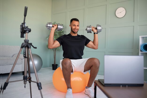 Hombre sonriente de tiro completo entrenando con pesas