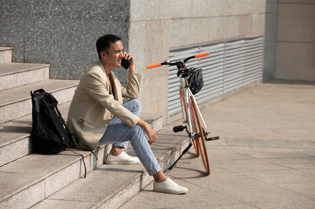 Hombre sonriente de tiro completo hablando por teléfono