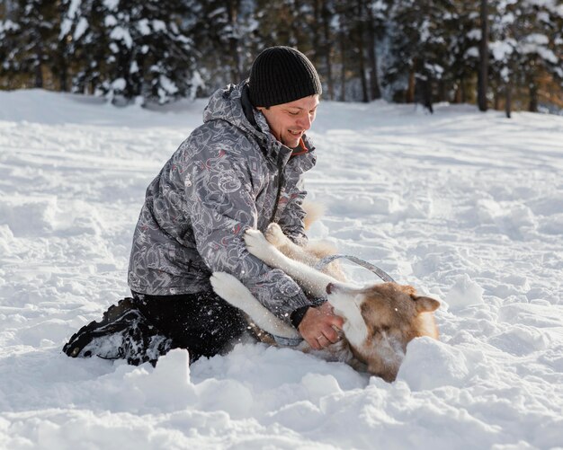 Hombre sonriente de tiro completo jugando con perro