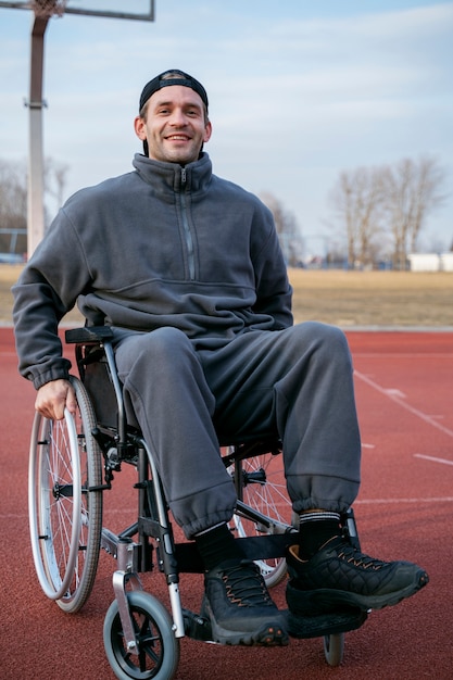 Foto gratuita hombre sonriente de tiro completo en silla de ruedas