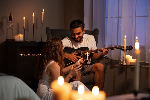 Hombre sonriente de tiro completo tocando la guitarra