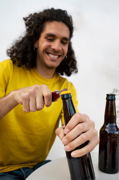 Foto gratuita hombre sonriente de tiro medio abriendo botella