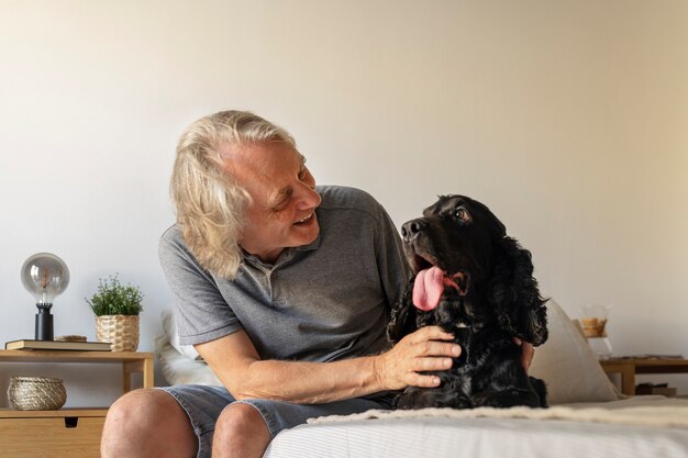 Foto gratuita hombre sonriente de tiro medio acariciando a un perro lindo