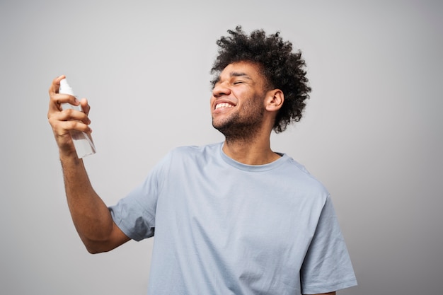 Foto gratuita hombre sonriente de tiro medio aplicando spray