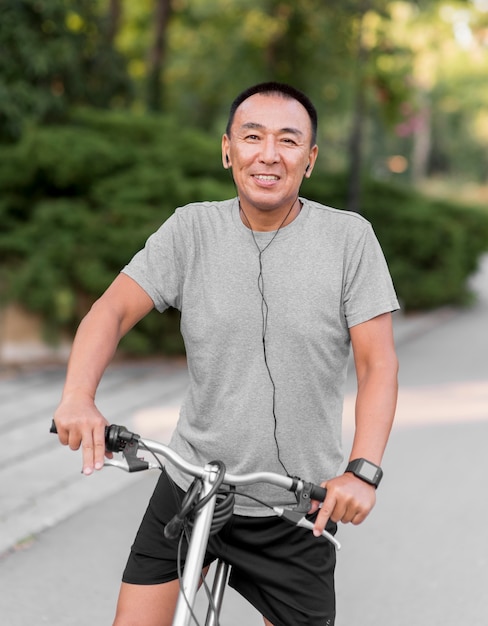 Hombre sonriente de tiro medio en bicicleta