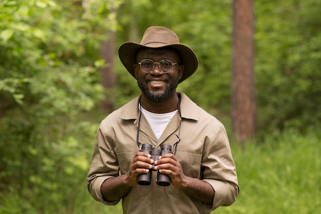 Hombre sonriente de tiro medio con binoculares