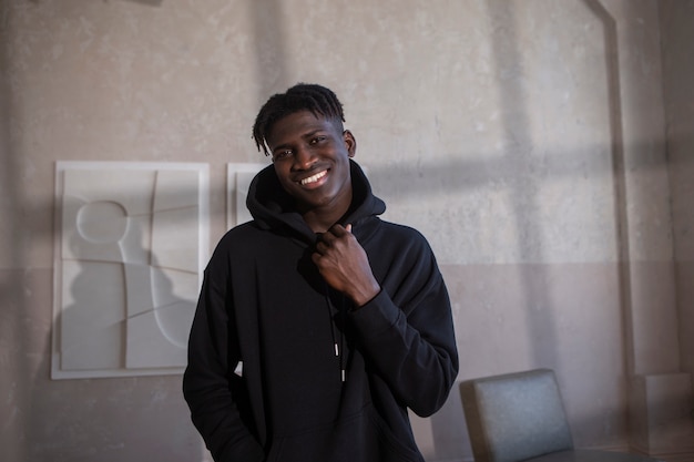 Hombre sonriente de tiro medio con capucha negra