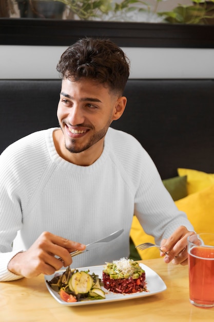 Hombre sonriente de tiro medio con comida