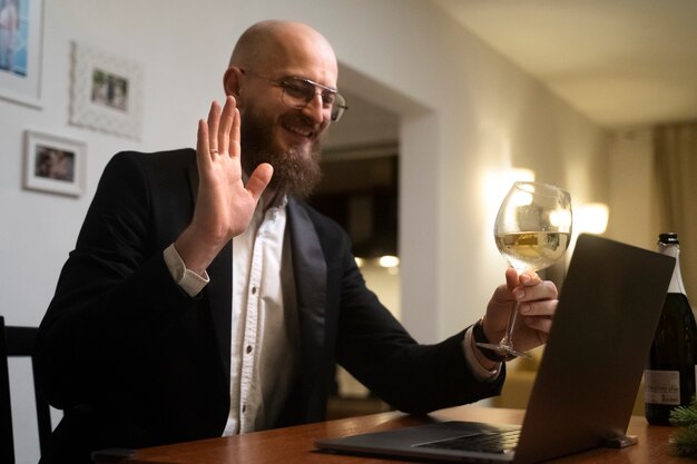 Hombre sonriente de tiro medio con computadora portátil en casa