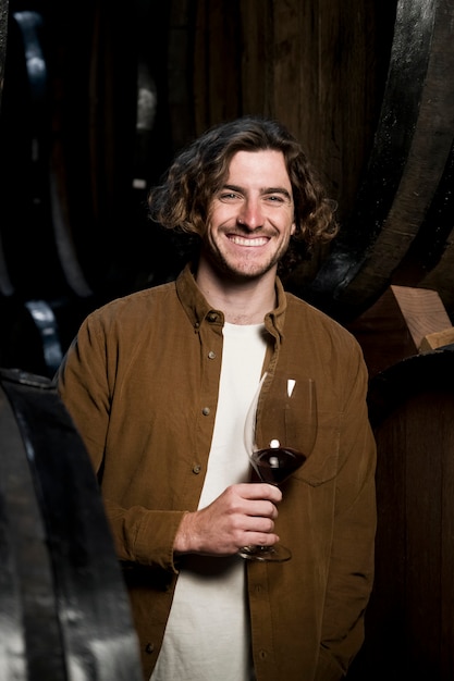 Hombre sonriente de tiro medio con copa de vino