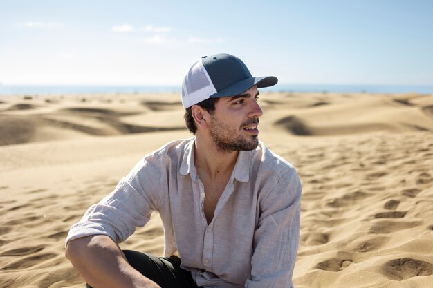 Hombre sonriente de tiro medio en el desierto