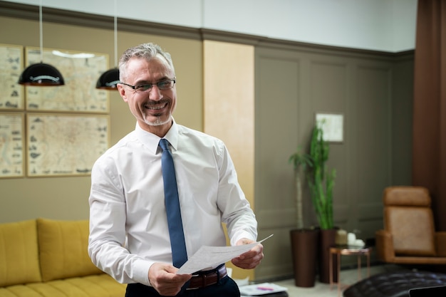 Hombre sonriente de tiro medio con documento