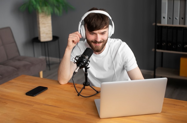 Hombre sonriente de tiro medio grabando podcast dentro
