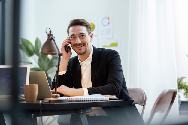 Hombre sonriente de tiro medio hablando por teléfono