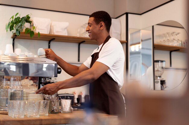 Hombre sonriente de tiro medio haciendo café