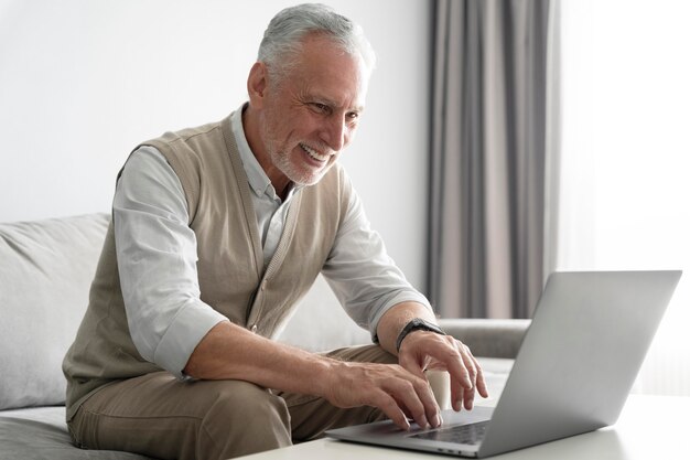 Hombre sonriente de tiro medio con laptop