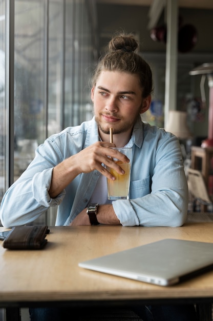 Hombre sonriente de tiro medio con moño desordenado