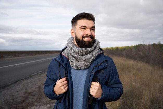 Hombre sonriente de tiro medio en la naturaleza