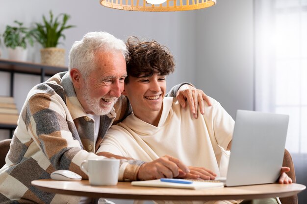 Hombre sonriente de tiro medio y niño con computadora portátil