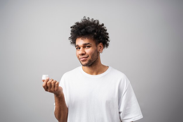 Hombre sonriente de tiro medio con recipiente de crema