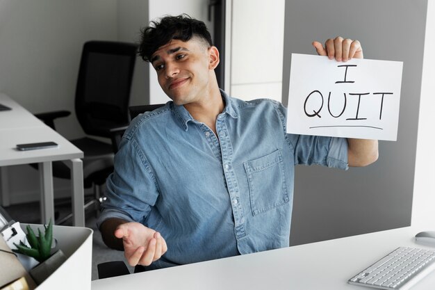 Hombre sonriente de tiro medio renunciando al trabajo