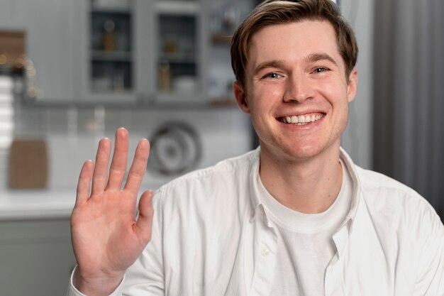 Hombre sonriente de tiro medio saludando