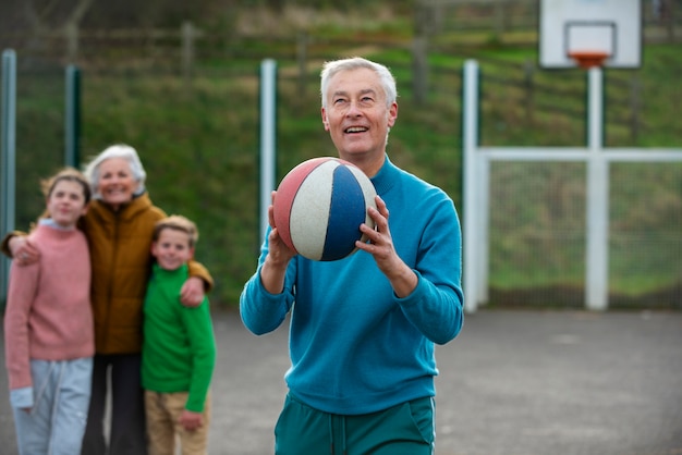 Hombre sonriente de tiro medio sosteniendo la bola