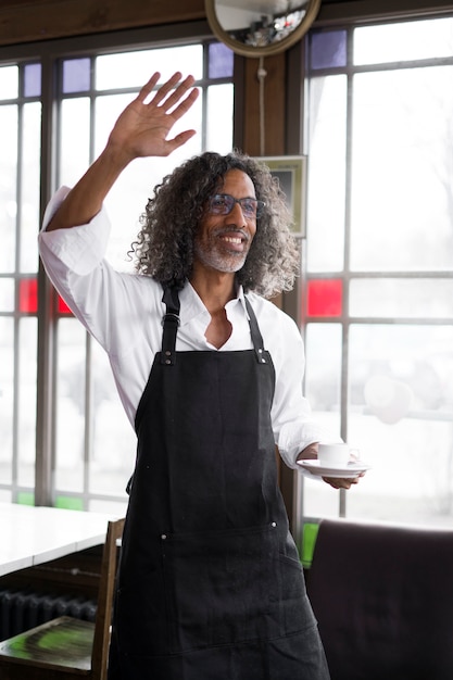 Foto gratuita hombre sonriente de tiro medio sosteniendo una taza de café