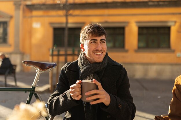 Hombre sonriente de tiro medio sosteniendo taza