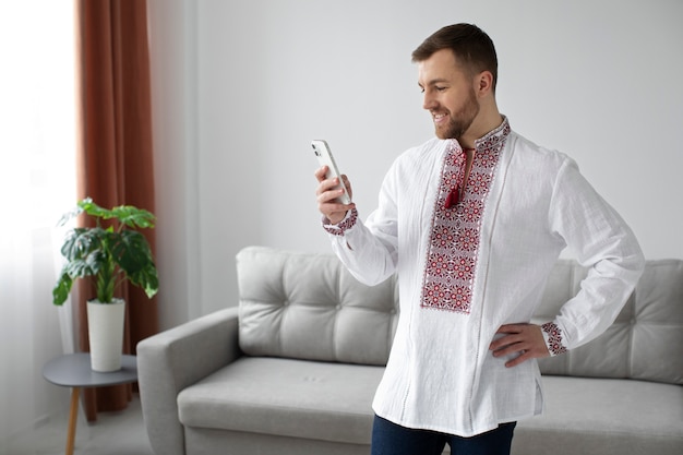 Hombre sonriente de tiro medio sosteniendo teléfono