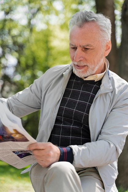 Foto gratuita hombre sonriente de tiro medio sujetando el periódico