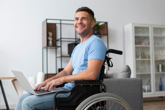 Hombre sonriente de tiro medio sujetando el portátil