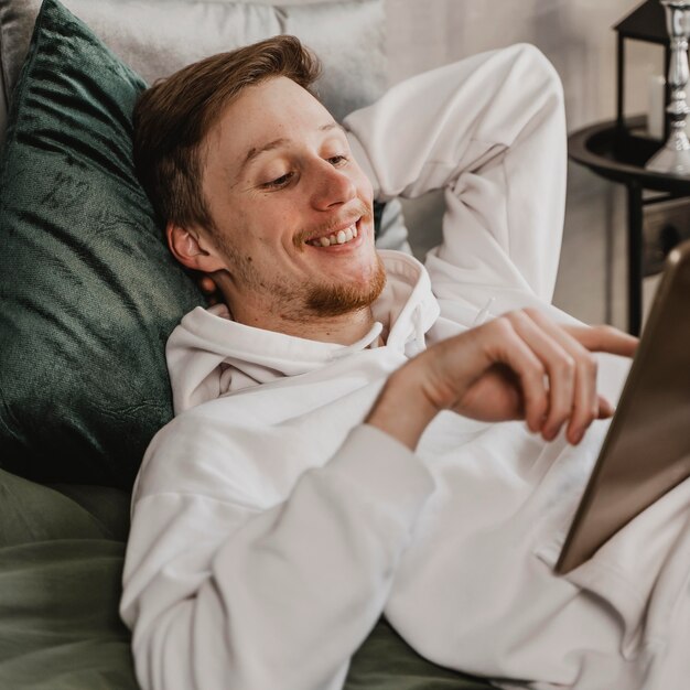 Hombre sonriente de tiro medio con tableta