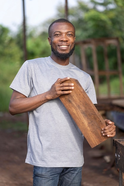 Foto gratuita hombre sonriente de tiro medio con tablón de madera