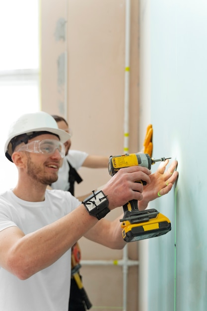 Foto gratuita hombre sonriente de tiro medio con taladro