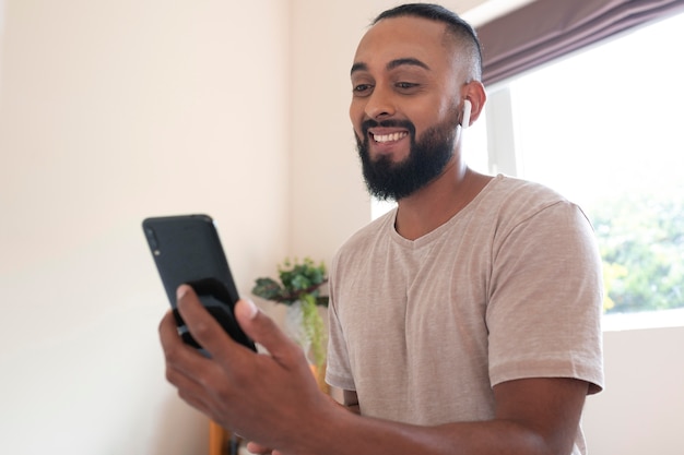 Hombre sonriente de tiro medio con teléfono